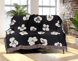 Atia Cheetah Print Cotton Throw Blanket in Black and Beige, draped over a sofa