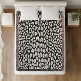 Delo Animal Print Cotton Blend Blanket Throw in Black, on a bed