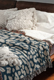 Delo Animal Print Cotton Blend Blanket Throw in Blue, draped over a chair