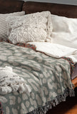 Delo Animal Print Cotton Blend Blanket Throw in Gray, draped over a chair