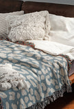 Delo Animal Print Cotton Blend Blanket Throw in Light Blue, draped over a chair