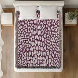 Delo Animal Print Cotton Blend Blanket Throw in Purple, on a bed