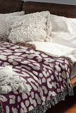 Delo Animal Print Cotton Blend Blanket Throw in Purple, draped over a chair