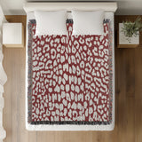 Delo Animal Print Cotton Blend Blanket Throw in Red, on a bed