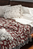Delo Animal Print Cotton Blend Blanket Throw in Red, draped over a chair