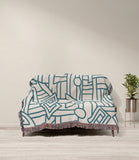 Diof Abstract Print Cotton Throw Blanket in Blue and Beige, draped over a sofa