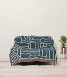 Diof Abstract Print Cotton Throw Blanket in Teal and Beige, draped over a sofa