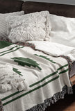 Ector Southwestern Cotton Blend Blanket Throw in Green and Off-White, draped over a chair