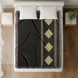 Ector Southwestern Cotton Blend Blanket Throw in Black and Dull Gold, on a bed