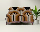 Farni Cotton Blend Blanket Throw in Burnt Orange, draped over a chair