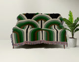 Farni Cotton Blend Blanket Throw in Green, draped over a chair