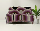 Farni Cotton Blend Blanket Throw in Purple, draped over a chair