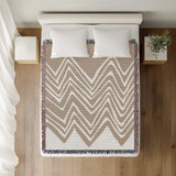 Addai Abstract Triangle Pattern Blanket Throw in Beige, on a bed