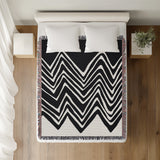 Addai Abstract Triangle Pattern Blanket Throw in Black, on a bed