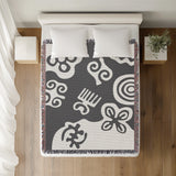 Addai Abstract Triangle Pattern Blanket Throw in Gray, on a bed