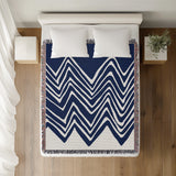 Addai Abstract Triangle Pattern Blanket Throw in Navy Blue, on a bed