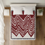 Addai Abstract Triangle Pattern Blanket Throw in Red, on a bed