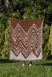 Addai Abstract Triangle Pattern Blanket Throw in Rust Brown, outdoors