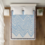 Addai Abstract Triangle Pattern Blanket Throw in Sky Blue, on a bed