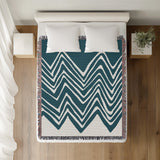 Addai Abstract Triangle Pattern Blanket Throw in Teal, on a bed
