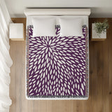 Addy Floral Cotton Throw Blanket in Purple, on a bed