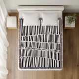 Afia Tribal Cotton Throw Blanket in Black, on a bed