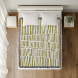 Afia Tribal Cotton Throw Blanket in Chartreuse, on a bed