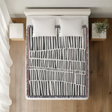 Afia Tribal Cotton Throw Blanket in Gray, on a bed