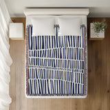 Afia Tribal Cotton Throw Blanket in Navy Blue, on a bed