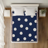 Akon Hand Woven Throw Blanket in Navy Blue, on a bed