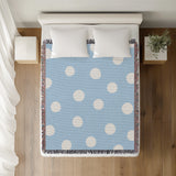 Akon Hand Woven Throw Blanket in Sky Blue, on a bed