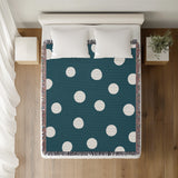 Akon Hand Woven Throw Blanket in Teal, on a bed