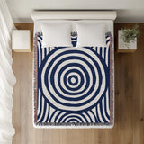 Alaka Circles Cotton Throw Blanket in Navy Blue, on a bed
