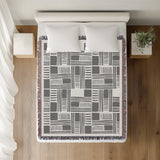 Anala Abstract Cotton Throw Blanket in Gray, on a bed