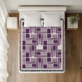 Anala Abstract Cotton Throw Blanket in Purple, on a bed