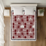 Anala Abstract Cotton Throw Blanket in Red, on a bed