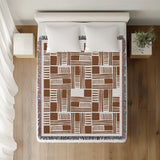 Anala Abstract Cotton Throw Blanket in Rust Brown, on a bed