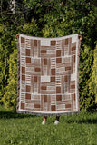 Anala Abstract Cotton Throw Blanket in Rust Brown, outdoors