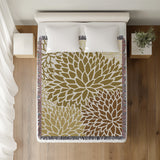 Arlo Floral Burst Cotton Throw Blanket in Dull Gold, on a bed