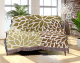 Arlo Floral Burst Cotton Throw Blanket in Dull Gold, draped over a sofa