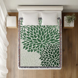 Arlo Floral Burst Cotton Throw Blanket in Green, on a bed