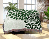 Arlo Floral Burst Cotton Throw Blanket in Green, draped over a sofa