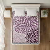 Arlo Floral Burst Cotton Throw Blanket in Purple, on a bed
