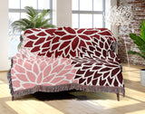 Arlo Floral Burst Cotton Throw Blanket in Red, draped over a sofa