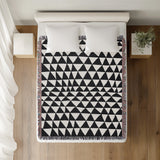 Asaba Abstract Cotton Throw Blanket in Black, on a bed