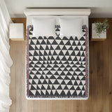 Asaba Abstract Cotton Throw Blanket in Gray, on a bed