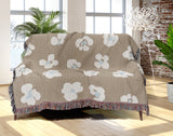 Atia Cheetah Print Cotton Throw Blanket in Beige and Blue, draped over a sofa