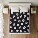 Atia Cheetah Print Cotton Throw Blanket in Black and Beige, on a bed