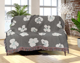Atia Cheetah Print Cotton Throw Blanket in Gray and Blue, draped over a sofa