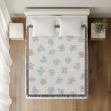 Atia Cheetah Print Cotton Throw Blanket in Light Blue and Beige, on a bed